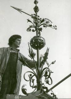 ARH Slg. Bartling 3484, Schmiedeeiserne Windfahne mit Richtungspfeil im barocken Stil auf Dachgiebel, seitlich gehalten von einem stehenden Mann, um 1975