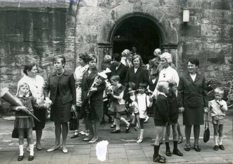 ARH Slg. Bartling 3489, Hauptportal unter dem Turm der ev. lutherische Liebfrauenkirche, Einschulkinder verlassen mit ihren Eltern nach dem Gottesdienst die Kirche, Neustadt a. Rbge., um 1975
