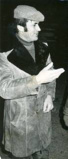 ARH Slg. Bartling 3563, Porträt von Mucha ... ??, mit Wildledermantel und Schlägermütze, mit der Rechten nach links zeigend,  Kniestück, Halbprofil, um 1975