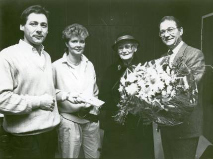 ARH Slg. Bartling 3654, Überreichung eines Blumenstraußes an eine ältere Kundin (mit Mantel und Hut) der Volksbank durch N. N. im Beisein von N. N. und Marion Krenz, Neustadt a. Rbge., um 1975
