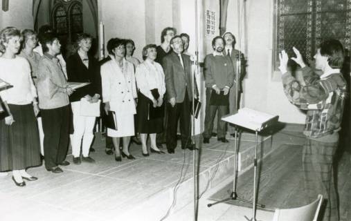 ARH Slg. Bartling 3733, Gemischter Chor unter der Leitung von N. N. bei der Probe in der Kirche, Blick vom Kirchenschiff auf den Chor mit dem Dirigenten (rechts), Schneeren (?), um 1980