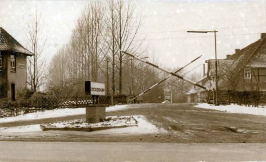 ARH Slg. Bartling 3799, Beschrankter Bahnübergang an der Dewitz-von-Woyna-Straße, leicht verschneit, Blick über das Firmenschild auf das Verwaltungsgebäude der Firma Eduard Dyckerhoff GmbH, 1972