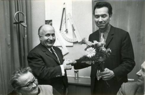 ARH Slg. Bartling 3830, Überreichung eines Blumengebindes an den Bürgermeister und Lehrer Rudolf Löffler (SPD) (rechts) durch den Bürgermeister a. D. Christian von Winkler (CDU) in einem Klassenzimmer, Poggenhagen, um 1972