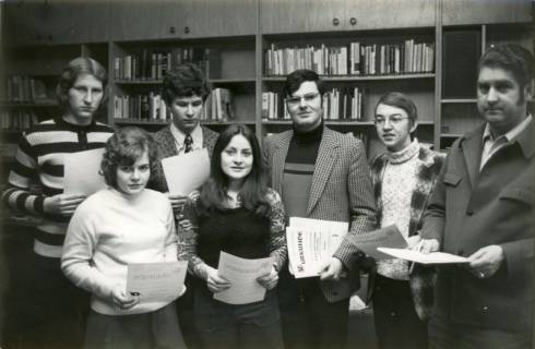 ARH Slg. Bartling 3865, DAG-Jugendheim, Gruppe von zwei jungen Frauen und fünf jungen Männern nebeneinander stehend mit einer Urkunde über die Teilnahme an einem Berufswettkampf in der Hand, Bordenau, 1972