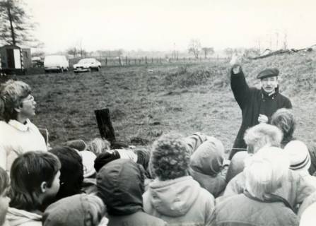 ARH Slg. Bartling 3976, Bockwindmühle, Führung einer Gruppe von Mitgliedern des Windmühlenvereins, Blick über die Hinterköpfe auf den Gästeführer N. N., der vor dem Mühlenhügel steht, Dudensen, 1988