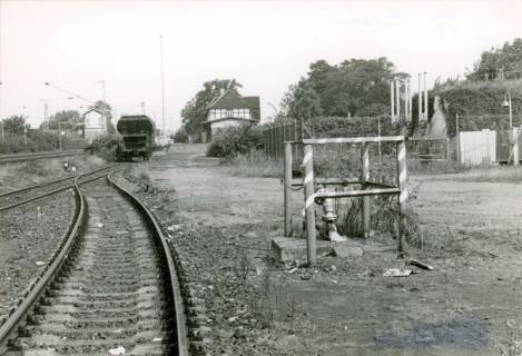 ARH Slg. Bartling 4041, Blick vom Nebengleis auf einen Schüttgutwagen und das Bahnhofsgebäude in Richtung Nienburg, Eilvese, um 1980