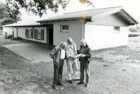 ARH Slg. Bartling 4065, Neues Schützenhaus der Schützengesellschaft, davor stehend drei Männer mit Plänen in der Hand, Eilvese, um 1980