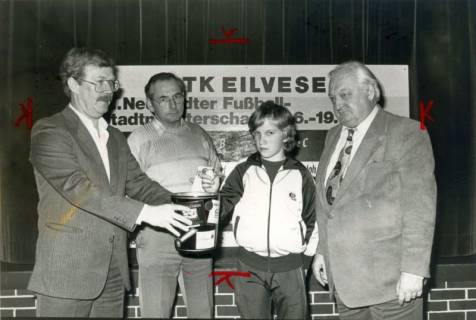 ARH Slg. Bartling 4078, Ziehung der Lose bei einer Verlosung des STK Eilvese (aus Anlass der Neustädter Fußball-Stadtmeisterschaft) durch einen Schüler und drei Erwachsene (rechts: Bürgermeister Henry Hahn), Eilvese, um 1980