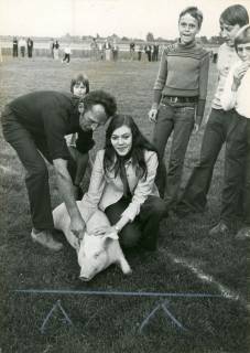 ARH Slg. Bartling 4123, Unter den Augen von drei Jugendlichen bringen Herbert Jurk und eine Frau ein Schwein als Preis für die Verlosung beim Sportfest auf dem Sportplatz des STK, Eilvese, 1974