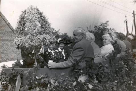 ARH Slg. Bartling 4156, Auf geschmücktem Wagen Erntekrone mit Senioren auf der rechten sowie Schützinnen auf der linken Seite sitzend beim Erntefestumzug, Empede, um 1975