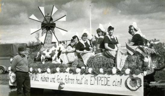 ARH Slg. Bartling 4157, Auf geschmücktem Wagen mit Themenschild "Hollandmädel hübsch und fein fahren heut´ in EMPEDE ein!" phantasievolle Windmühle und Frauen, gekleidet wie "Frau Antje" beim Erntefestumzug, Empede, um 1975
