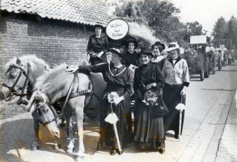 ARH Slg. Bartling 4160, Frauengruppe in schwarzen Maxikleidern mit zwei Haflinger-Pferden und Themenschild "Wie fohrt taun Armbeer" Erntefestumzug, Empede, um 1975