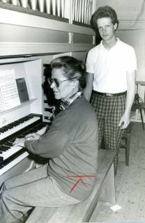 ARH Slg. Bartling 4184, Hilde Hahn beim Spiel auf der Hagener Orgel mit zwei Manualen, hinter ihr stehend ein Assistent, Hagen, um 1990