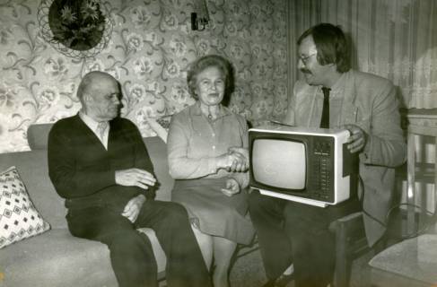 ARH Slg. Bartling 4204, Überreichung eines Fernsehers an ein älteres Ehepaar in dessen Wohnzimmer durch den Leiter der Volksbankfiliale Werner Brauner, Mariensee, vor 1990
