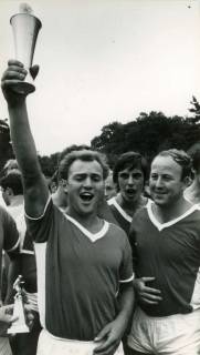 ARH Slg. Bartling 4281, Zwei Spieler vom Fußballverein Germania recken den gewonnenen jubelnd Pokal in die Höhe, Helstorf, 1969