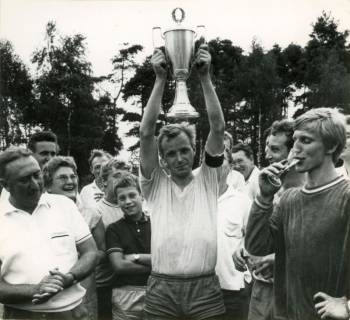 ARH Slg. Bartling 4283, Ein Spieler des Fußballvereins Germania Helstorf reckt den gewonnenen Wiegmann-Pokal in die Höhe zur Freude der umstehenden Fans, Helstorf, 1969