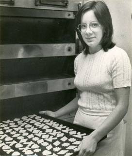 ARH Slg. Bartling 4298, Präsentation eines Backblechs voller Kekse vor dem Backofen der Bäckerei Ahrens durch Karin Ahrens, Lutter, 1972