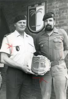 ARH Slg. Bartling 4342, Überreichung eines Kuchens in Form eines Wappens des PzGrenBtl 33 an den OvD der Kaserne N. N. (in sommerlicher Dienstuniform) durch Kompaniechef Hauptmann Busch (in Arbeitsuniform), Luttmersen, um 1985