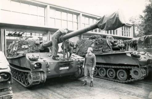 ARH Slg. Bartling 4353, Zwei Soldaten bei Wartungsarbeiten an zwei Panzern vor einer Halle, Luttmersen, zwischen 1985/1999