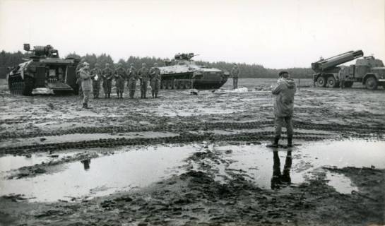 ARH Slg. Bartling 4361, Zwei Panzer und ein Raketenwerfer im feuchten Gelände des Standortübungsplatzes, sechs Soldaten einer Panzerbesatzung, die vor ihrem Panzer in Reih und Glied angetreten sind, lassen sich von einem Soldaten (r.) fotografieren, Luttmersen, um 1975