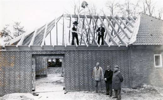 ARH Slg. Bartling 4458, Errichtung eines Anbaus an die Friedhofskapelle, Dachstuhl mit aufgesetztem Richtkranz, unten drei Zuschauer (darunter Pastor Adolf Höhle, Mitte), Mariensee, um 1980