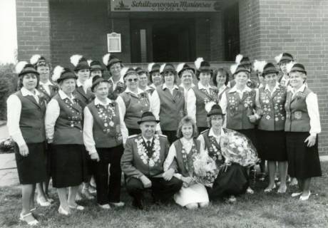 ARH Slg. Bartling 4482, Gruppenbild mit zahlreichen uniformierten Schützinnen mit Hut und dem Schützenkönig vor dem Eingang zum Schützenhaus des Schützenvereins, Mariensee, um 1975