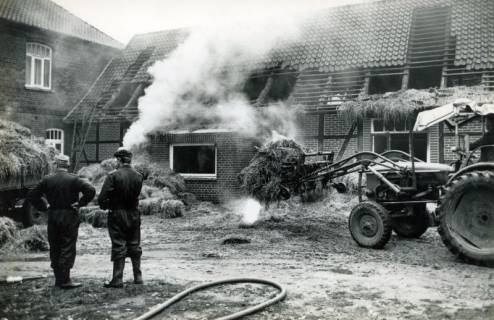 ARH Slg. Bartling 4507, Bäuerliches Wohnhaus mit Scheune nach dem Großbrand bei der Beseitigung des qualmenden Strohs, Laderholz, 1970