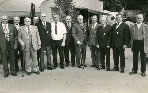 ARH Slg. Bartling 4561, Ehrung der Gründer der Feuerwehr Mardorf, Gruppenbild (Ganzfigur) mit zwölf nebeneinander stehenden älteren Herren, Mardorf, 1974