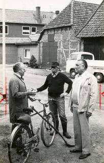 ARH Slg. Bartling 4571, Dorfgemeinschaft Mardorf in spontanem Gespräch auf der Straße vor einem alten Scheunengebäude mit neuem Anbau, Mardorf, um 1980