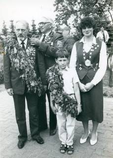 ARH Slg. Bartling 4715, Schützenkönige und -königin auf einem gepflasterten Platz nebeneinander stehend beim Schützenfest (2 Ex.), Nöpke, um 1975