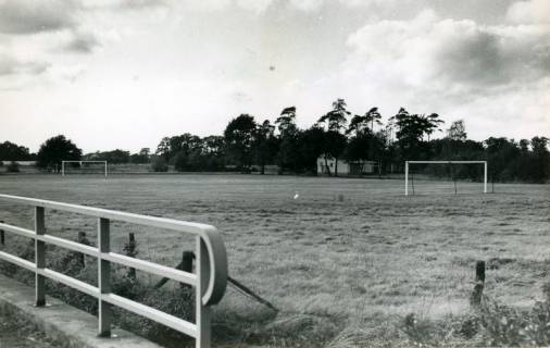 ARH Slg. Bartling 4791, Der neu geschaffene zweite Fußballplatz, Blick über das Brückengeländer und den Platz auf das Vereinsheim, Otternhagen, 1973