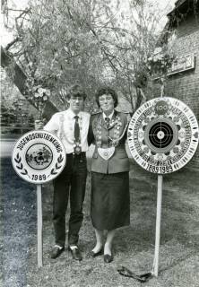 ARH Slg. Bartling 5017, Jugendschützenkönig mit der Schützenscheibe in der Rechten neben der Schützenkönigin, die in der Linken eine Scheibe hält mit einem Fadenkreuz auf der Wiese vor der Gaststätte Bartling beim Schützenfest, Wulfelade, 1989