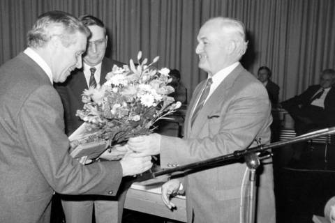 ARH Slg. Weber 02-022/0003, Gehrdens Bürgermeister Helmut Oberheide überreicht dem FDP-Ratsmitglied aus Everloh Ernst-August Ruppel einen Blumenstrauß, in der Mitte Heinrich Berkefeld, zwischen 1980/1990