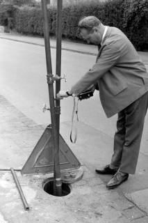 ARH Slg. Weber 02-026/0011, Ein Mann misst mit einem Messgerät den Wasserdruck im Nedderntor, Gehrden, zwischen 1970/1980
