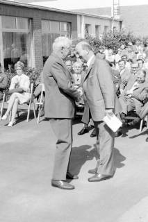 ARH Slg. Weber 02-030/0005, Gehrdens Bürgermeister Gerhard Oberkönig und ein weiterer Mann schütteln sich vor einem Publikum die Hände, zwischen 1970/1980