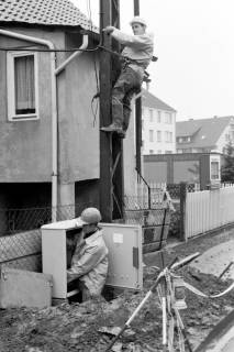 ARH Slg. Weber 02-030/0018, Zwei Männer arbeiten an einem Strommasten und -kasten in der Südstraße / Ecke Lange Feldstraße, Gehrden, zwischen 1980/1990