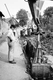 ARH Slg. Weber 02-037/0018, Arbeiter verlegen Rohre in ein ausgehobenes Loch , zwischen 1980/1990