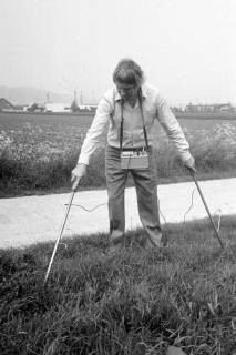ARH Slg. Weber 02-060/0005, Ein Mann misst den Boden eines Feldes zur Lecksuche bei einem Wasserrohrbruch im Langen Feld, Gehrden, zwischen 1980/1990