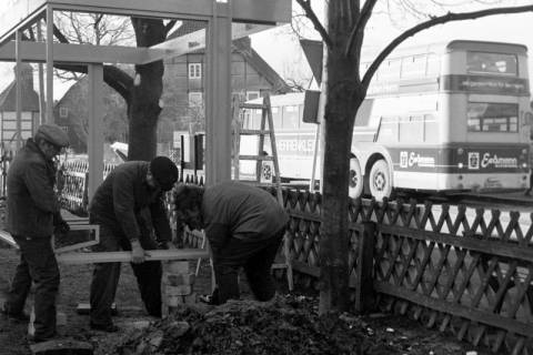 ARH Slg. Weber 02-066/0001, Drei Männer beim Aufbau einer Bushaltestelle vor dem Dorfgemeinschaftshaus, Redderse, zwischen 1980/1990