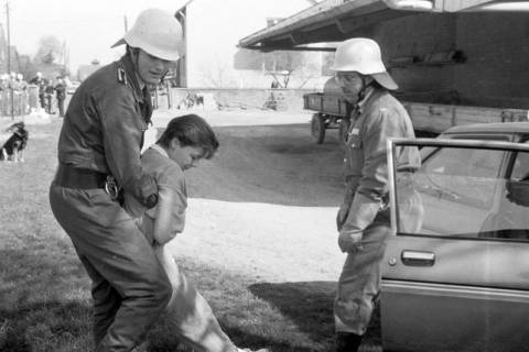 ARH Slg. Weber 02-066/0006, Zwei Mitglieder der Feuerwehr bei der Übung eine bewusstlose Person aus einem Auto zu retten auf einem Bauernhof, zwischen 1980/1990