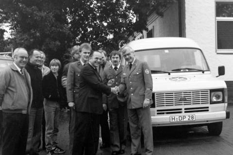 ARH Slg. Weber 02-081/0002, Schlüsselübergabe eines neuen Einsatzfahrzeugs an den JUH-Ortsgruppenleiter Hans-Martin Ulrich (rechts) vor der Alten Schule, Lenthe , zwischen 1980/1990