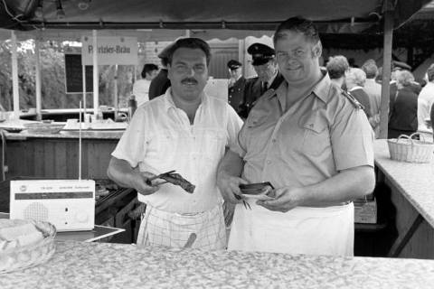 ARH Slg. Weber 02-087/0018, V.l. N.N. und Günter Hogrefe von der Ortsfeuerwehr Ditterke in einem Grillstand auf einem Fest, zwischen 1980/1990