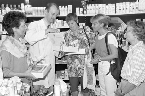 ARH Slg. Weber 02-092/0011, Mehrere Frauen erhalten in einer Apotheke Geschenke von einem Apotheker, zwischen 1980/1990