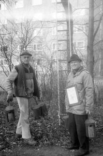 ARH Slg. Weber 02-094/0009, V.l. N.N. und Georg Wallus bei einer Nisthöhlenkontrolle vom Vogelschutz- und Vogelliebhaberverein Gehrden, im Hintergrund das Schwesternhochhaus am Robert-Koch-Krankenhaus, Gehrden, zwischen 1980/1990