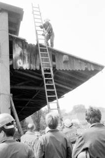 ARH Slg. Weber 02-106/0012, Mitglieder der Feuerwehr klettern mithilfe einer Leiter auf ein Scheunendach, zwischen 1980/1990