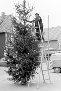 ARH Slg. Weber 02-120/0019, Helmut Jelinek vom städtischen Baubetriebshof bei der Aufstellung eines Weihnachtsbaums auf dem Marktplatz, Gehrden, zwischen 1980/1990