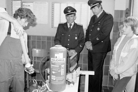 ARH Slg. Weber 02-121/0011, Ein Mann befüllt vor Mitgliedern der Feuerwehr einen Feuerlöscher, zwischen 1980/1990