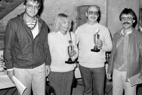 ARH Slg. Weber 02-126/0017, Vier Personen nach einer Siegerehrung innerhalb eines Sportvereins mit Pokalen und Urkunden, zwischen 1980/1990