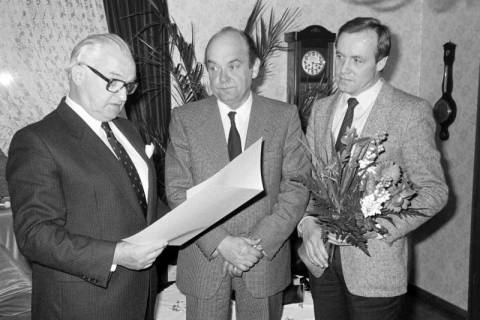 ARH Slg. Weber 02-127/0024, Bürgermeister Helmut Oberheide (links) und Hans Bildhauer (rechts) überreichen eine Urkunde und einen Blumenstrauß an Georg Weber sen. zur Verabschiedung als stellvertretender Stadtdirektor, Gehrden, 1985
