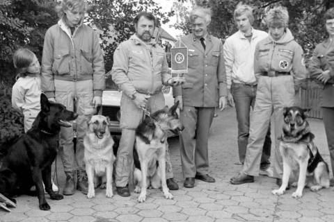 ARH Slg. Weber 02-129/0003, Gruppenfoto mit Mitgliedern der Johanniter und ihren ausgebildeten Hunden, Bildmitte Ortsverbandsleiter Hans-Martin Ulrich (in Uniform), Gehrden, zwischen 1980/1990
